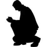 De rodillas orando hombre