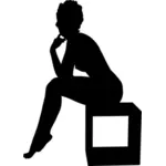 Kvinna sitter på en låda